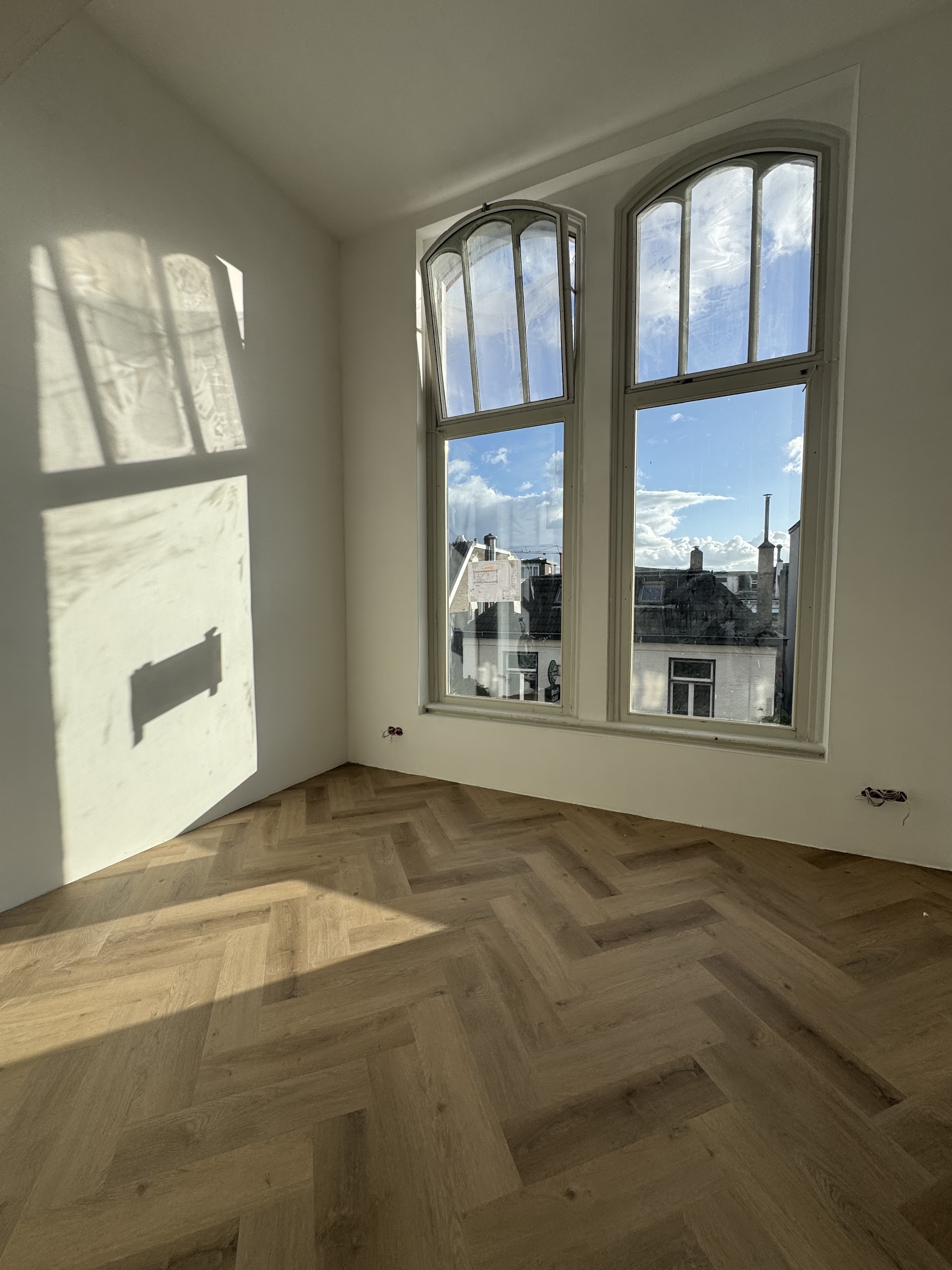Visgraatvloer in een kamer met boogramen