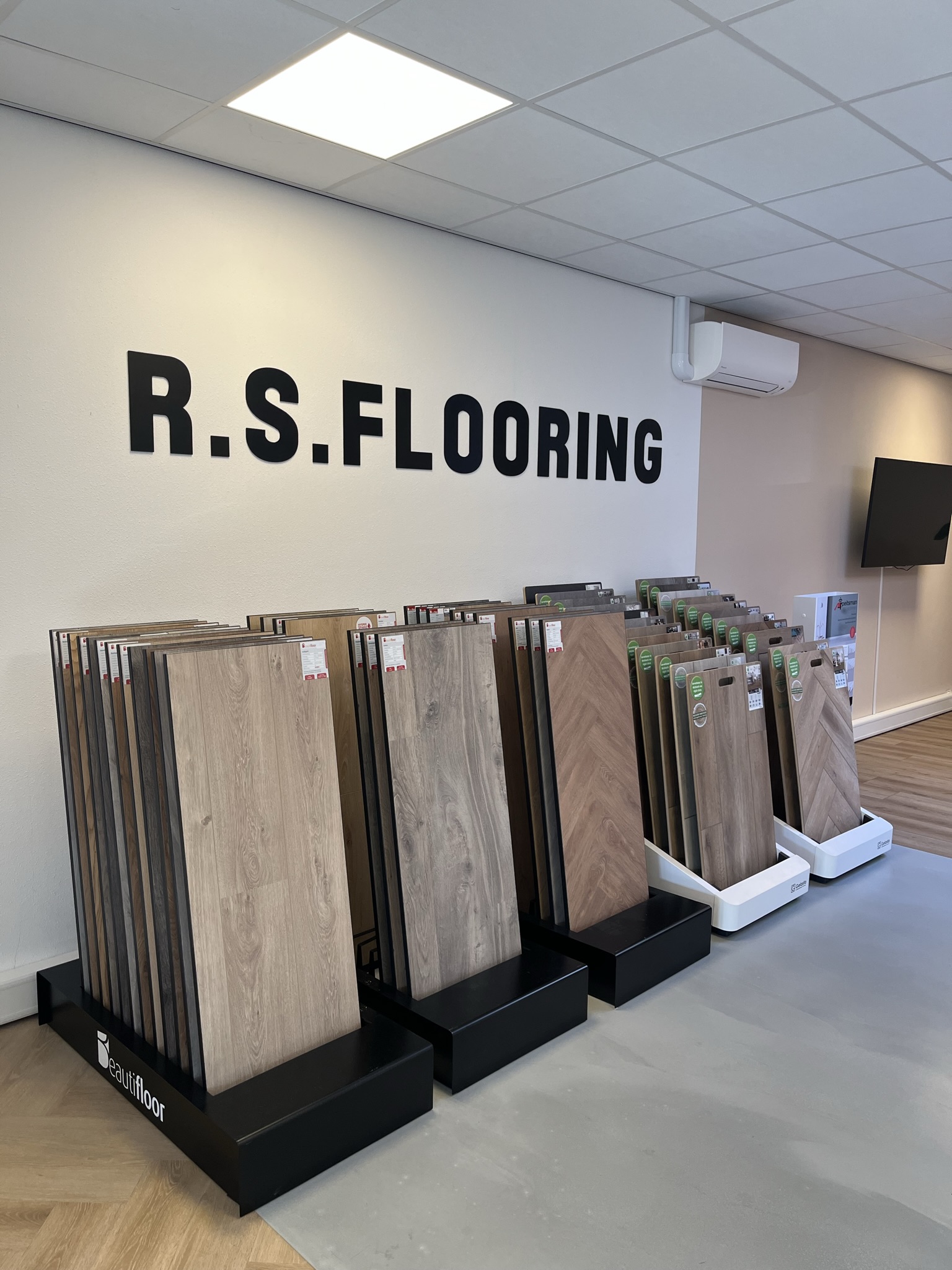 Showroom met R.S. Flooring op de muur en rekken met vloerstalen