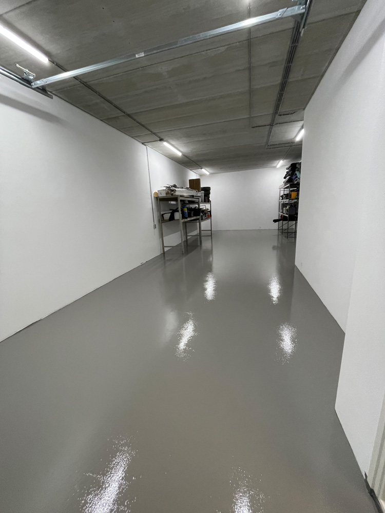 Glanzende grijze vloer in een lange showroomruimte