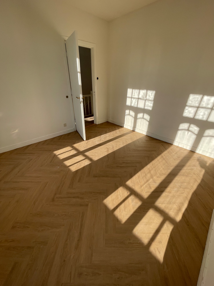 Eiken visgraatvloer met zonlicht door de ramen