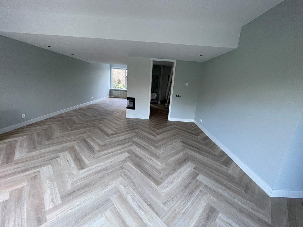 Lange woonkamer met lichte PVC visgraat